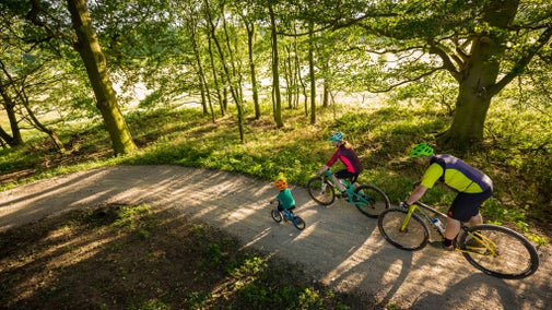 Family visitors cycling on one of Nostell's bike trails in Summer
